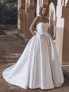 a woman in a white wedding dress posing for the camera