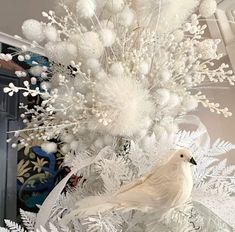 a white christmas tree decorated with snowflakes and birds on it's branches