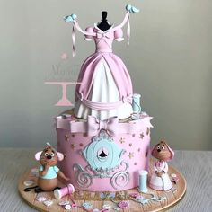 a pink and white cake with a dress on top