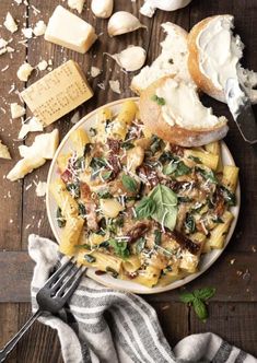 pasta with spinach and cheese on a plate next to bread, garlic and parmesan