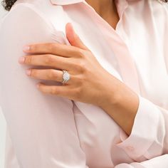 a woman wearing a diamond ring on her left hand and pink shirt with white background