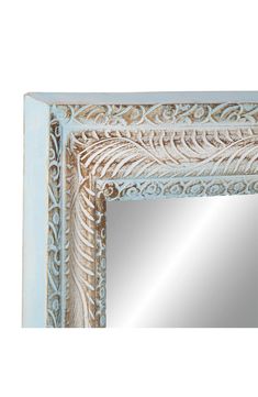 an ornate blue frame mirror with white trimming on the edges and gold leaf design