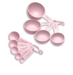 pink measuring spoons and measuring cups on a white background