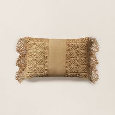 a tan pillow with fringes on it