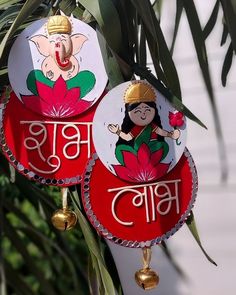 two red and white ornaments hanging from a palm tree with an elephant on it's head