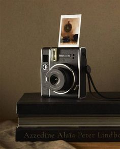 an old camera sitting on top of a stack of books