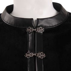 the back of a black dress with silver accents on it's collar and cuffs