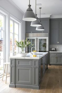 an image of a kitchen with gray cabinets and white counter tops on the left side