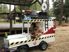 two children are riding in a toy fire truck