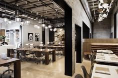 an empty restaurant with tables and chairs in the center, lights hanging from the ceiling