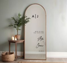 a mirror sitting on top of a wooden floor next to a table and potted plant