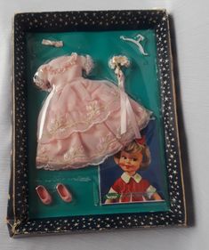 a doll in a box with shoes and accessories