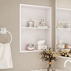 a bathroom sink with two white shelves above it and flowers in the vase on the counter