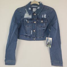 Elevate your wardrobe with this trendy Wax Jean denim jacket in a beautiful medium wash. The short-length jacket features long sleeves and a comfortable, stretchy fabric that flatters the figure. The cotton blend outer shell material and denim fabric type exude durability and style, making it a perfect fit for a casual outing. This versatile piece is perfect for women of all sizes, especially juniors, with its S size type. The jacket is available in a stunning blue color, making it an ideal choice for any occasion. The Wax Jean denim jacket is a must-have for women who love to stay in style. With its flattering design and stretchy fabric, it is the perfect companion for a stylish and comfortable day out. Get your hands on this trendy piece and elevate your fashion game today! Distressed Cropped Denim Jacket, Womens Distressed Jeans, Hooded Jean Jackets, Womens Denim Vest, Denim Jacket With Hoodie, Dark Denim Jacket, Embroidered Jean Jacket, Denim Hoodie, Waxed Jeans