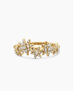 a gold ring with stars and diamonds on the front, set against a white background