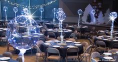 tables and chairs are set up for an event with lights on the top of them