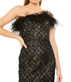 a woman wearing a black dress with feathers on it