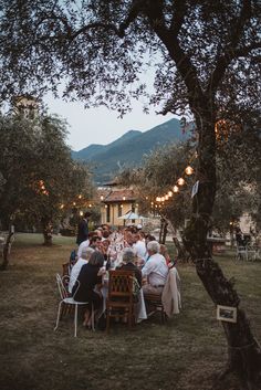 a group of people sitting around a table in the middle of a field at night