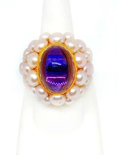 New With Tags! Authentic Mimi 18K Yellow Gold Amethyst and Violet Pearls Ring 18 Karat Yellow Gold Amethyst weighing 12.91 Carats Violet Pearls 33.8 grams Size 7.75 Retail: $7,080.00 UPC: A036A02 Ships from Cleveland, Ohio and comes with a Mimi Inner and Outer box, plus a complimentary cleaning cloth from DeWitt. Luxury Purple Cabochon Amethyst Ring, Luxury Purple Amethyst Cabochon Ring, Luxury Purple Amethyst Oval Cabochon Ring, Fine Jewelry Purple Amethyst Cabochon Ring, Purple Amethyst Cabochon Ring Fine Jewelry, Luxury Purple Cabochon Jewelry, Formal Purple Cabochon Amethyst Ring, Formal Purple Cabochon Ring, Pearls Ring