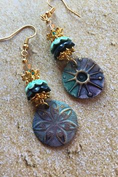 These Ceramic Earrings are made with charms made by an artisan.  Each earring has a different design and the earrings are accented with ceramic and metal flower bead caps and Swarovski crystals Bohemian Drop Earrings With Unique Variations, Gold Bohemian Earrings With Unique Variations, Artistic Bronze Dangle Jewelry, Green Bohemian Earrings With Unique Variations, Green Earrings For Jewelry Making, Green Drop Earrings With Unique Variations, Handmade Green Bohemian Plug Earrings, Artisan Dangle Flower Earrings, Artistic Green Earrings For Festival