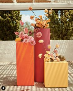 three vases with flowers in them sitting on a table