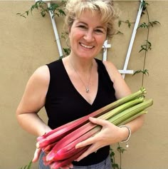 a woman is holding some vegetables in her hands