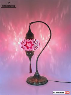 a pink lamp with a tassel hanging from it's end on a table