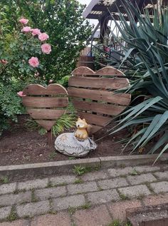 a statue of a dog sitting on top of a rock next to a wooden fence