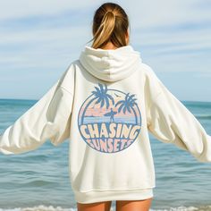 Sunset Hoodie, Beach Sweatshirt, Chasing Sunset Hoodie, Beach Sweatshirt, Summer Sweatshirt, Gift for Her, Beach Pullover, Beach Shirt This unisex heavy blend hooded sweatshirt is relaxation itself. Made with a thick blend of cotton and polyester, it feels plush, soft and warm, a perfect choice for any cold day. In the front, the spacious kangaroo pocket adds daily practicality while the hood's drawstring is the same color as the base sweater for extra style points. .: Made with a medium-heavy f White Letter Print Hoodie For Beach Season, Casual White Hoodie For Beach Season, Oversized Hooded Top For Vacation, Beach Season Graphic Print Hoodie Sweatshirt, White Graphic Print Beach Hoodie, White Graphic Print Hoodie For Beach, Casual Vacation Hoodie Top, Oversized Hoodie Sweatshirt For Beach, White Long Sleeve Hoodie For Beach