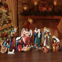 a group of figurines sitting on top of a wooden table next to a christmas tree