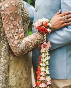 two people standing next to each other holding flowers