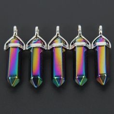 four different colored glass beads on a black surface