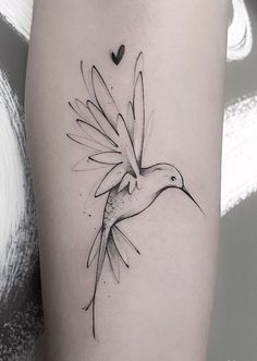 a black and white bird tattoo on the right thigh, with hearts in the background