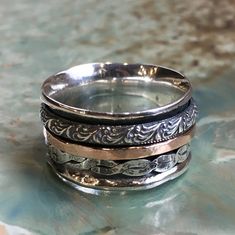 Hidden Place This spinner unisex ring is a true beauty. The wide silver band is adorned with a gold filled spinner ring and two detailed silver spinners. (R2459) © 2011-2017 Artisanimpact Inc. All rights reserved. Construction & Dimensions: Sterling silver, gold filled Approximate width: 12mm (0.47 inch) please indicate your size in your order. About our jewelry Artisanlook offers an exciting collection, designed and made by artisanimpact inc, especially for occasions: wedding, engagement an Bohemian Wide Band Rings For Anniversary, Bohemian Rings With Engraved Wide Band, Bohemian Wide Band Engraved Rings, Bohemian Wide Band Rings Engraved, Simple Ring Band, Silver And Gold Spinner Ring, Handmade Sterling Silver Spiritual Filigree Ring, Wide Silver Band, Gold Band Wedding Ring