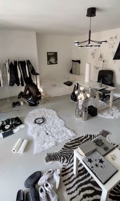 a room filled with lots of clothes and shoes on top of a white floor covered in fur