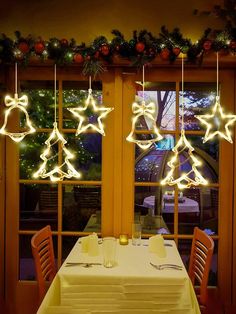 the lights are hanging from the ceiling above the table in the dining room, and it looks like they have been decorated for christmas