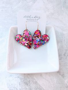 These gorgeous acrylic chunky glitter heart earrings are a must have! They are extremely lightweight and hooks are gold-plated stainless steel or stainless steel, use the pull down tab to choose your hook color. They measure 2.75 in., which includes the length of the hook. Choose from purple chunky glitter or multi-colored neon pink chunky glitter. Be sure to grab the matching studs for your mini me. Fun Heart-shaped Earrings For Valentine's Day, Chandbalis Earrings, Valentine Earrings, Resin Creations, Valentines Earrings, Glitter Acrylic, Resin Projects, Glitter Earrings, Glitter Acrylics