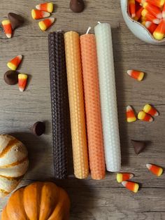 halloween candy sticks are arranged on a table next to pumpkins and chocolate candies