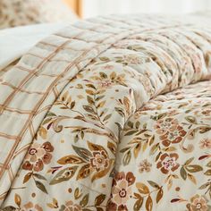 the comforter is made up with flowers and leaves on it's side,