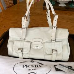 Prada White Handbag With Tag And Bag Bought And Never Used Two Small Stains. No Idea How They Got There Since It Has Been Sitting In The Bag In My Closet. Forgot It Was Even There. I Guess I’m Not That Into It. Thrift Manifestation, Bags Prada, White Handbag, Prada Bags, In The Bag, The Bag, Prada Bag, My Closet, Prada