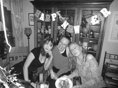 three women and one man are posing for a photo in front of a birthday banner