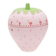 a pink and green strawberry shaped clock on a white background with thermometer in front of it