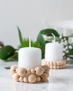 two white candles sitting on top of a table