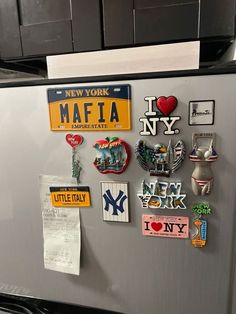 magnets on the side of a refrigerator in a kitchen with new york license plates