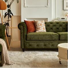 a living room filled with green couches and pillows