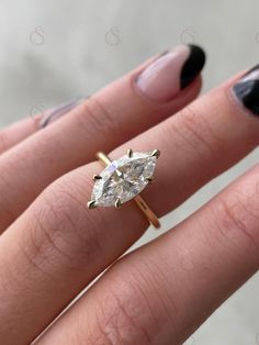 a woman's hand with a ring on it and a diamond in the middle