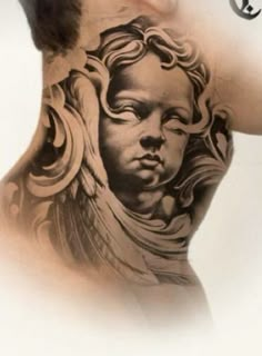 the back of a woman's neck with an angel tattoo on her shoulder and chest