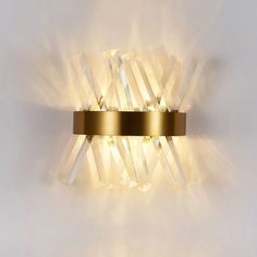 a wall light that is made out of glass and gold plating with some lights on it