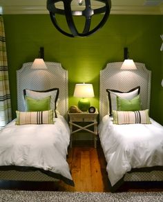 two beds in a room with green walls