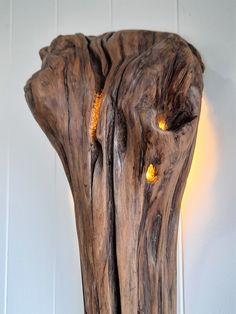 a piece of wood that has been carved into a vase with yellow lights on it